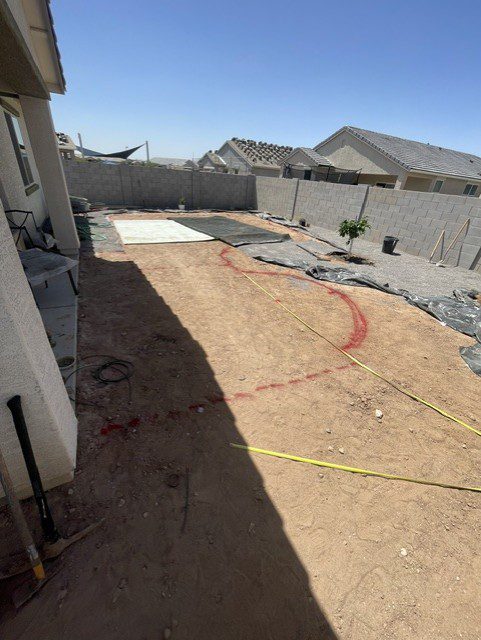 Bare dirt backyard with paver patio layout marked out before installation in Phoenix, Arizona