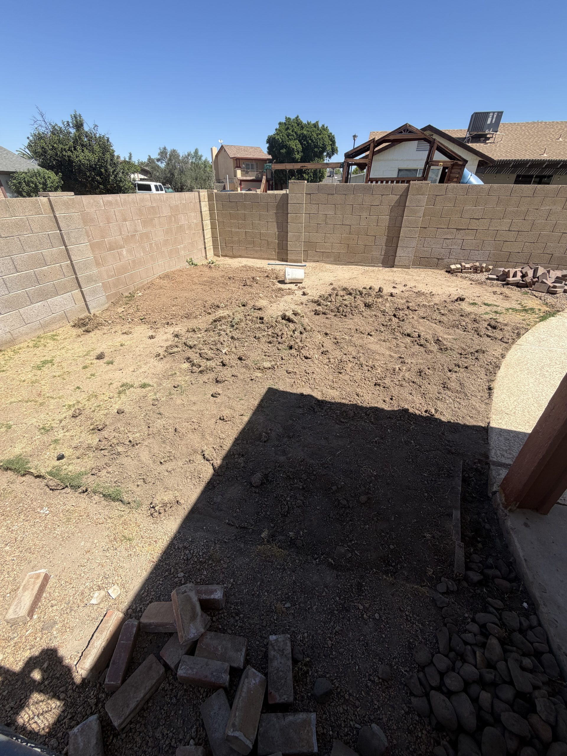 Bare dirt backyard before artificial turf installation in Phoenix, AZ